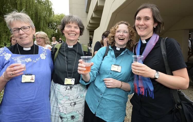 Women react after Church of England synod approves ordination of women bishops, July 14.