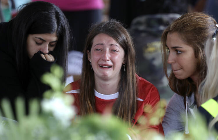 A woman cries ahead of a state funeral for some of the victims of last Wednesday's earthquake, in Amatrice, central Italy, Aug. 30. (AP Photo/Andrew Medichini)