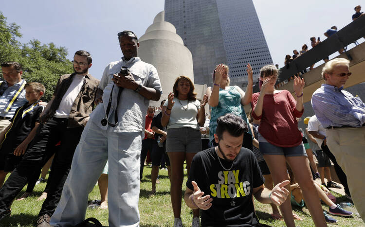 People take part in a prayer vigil at Thanksgiving Square, Friday, July 8, 2016, in Dallas.. (AP Photo/Eric Gay)