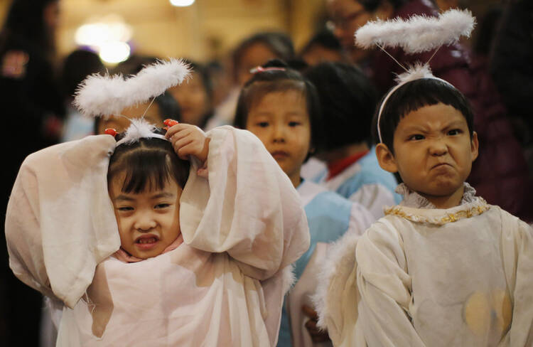 Children dressed as angels react as they attend Christmas Mass at Catholic church in Beijing, December 24. 