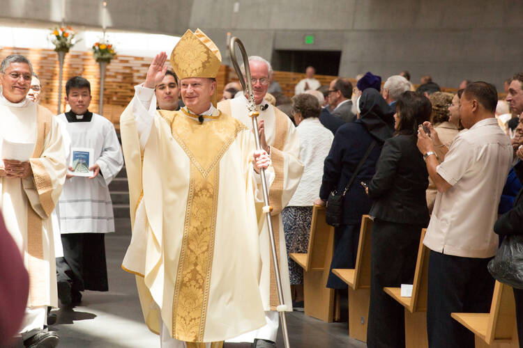 Bishop Michael C. Barber waves to the congregation after being installed as the fifth bishop of the Diocese of Oakland, Calif., May 25, 2013, at the Cathedral of Christ the Light. The 58-year-old Jesuit priest was previously the director of spiritual formation at St. John's Seminary in Brighton, Mass. (CNS photo/Jose Luis Aguirre, The Catholic Voice)