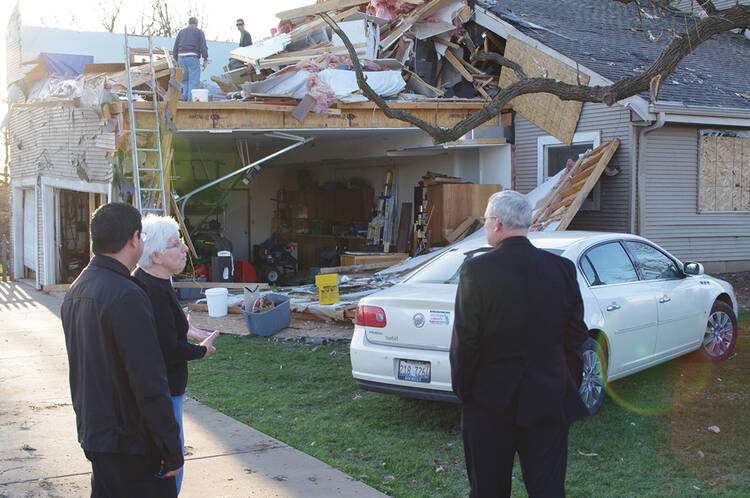 GOOD SHEPHERDS. Rev. Johnson Lopez, left, and Bishop David J. Malloy visit a home in Illinois damaged by a tornado last April. 