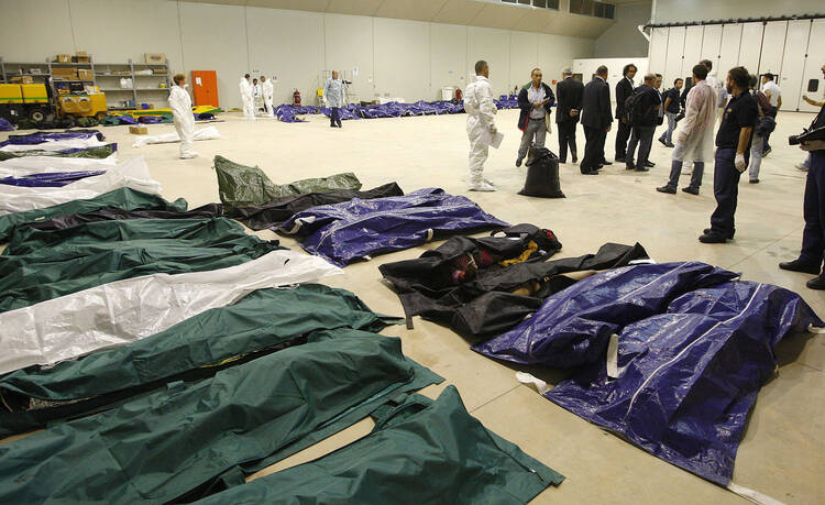 The bodies of African migrants lie in a hangar of the Lampedusa airport