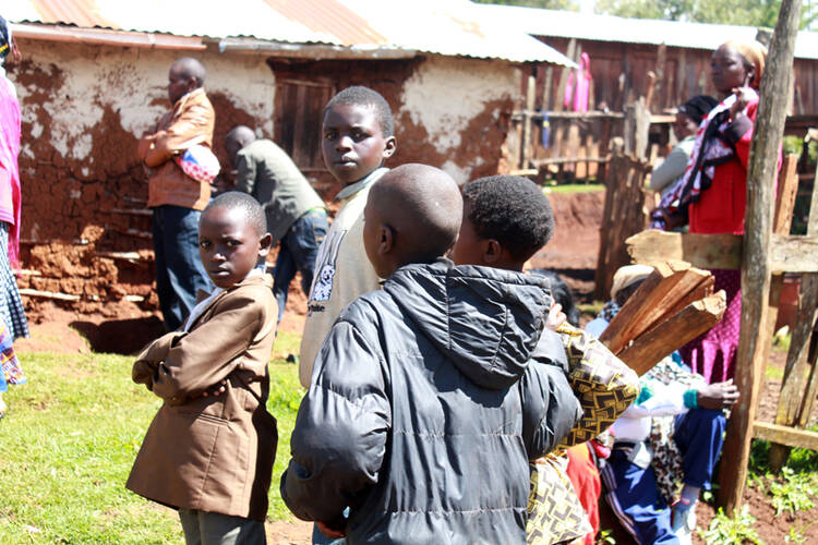 Tom Gowon, 9, in a brown jacket, with his fellow refugees at Baga Sola camp, Chad. The fighting between the government and Boko Haram has displaced thousands of children. (Photo by Tonny Onyulo, courtesy of USA Today)