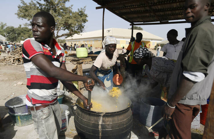 People fleeing Boko Haram violence in the northeast region of Nigeria cook food at a camp for internally displaced people in Yola Jan. 13. (CNS photo/Afolabi Sotunde, Reuters)