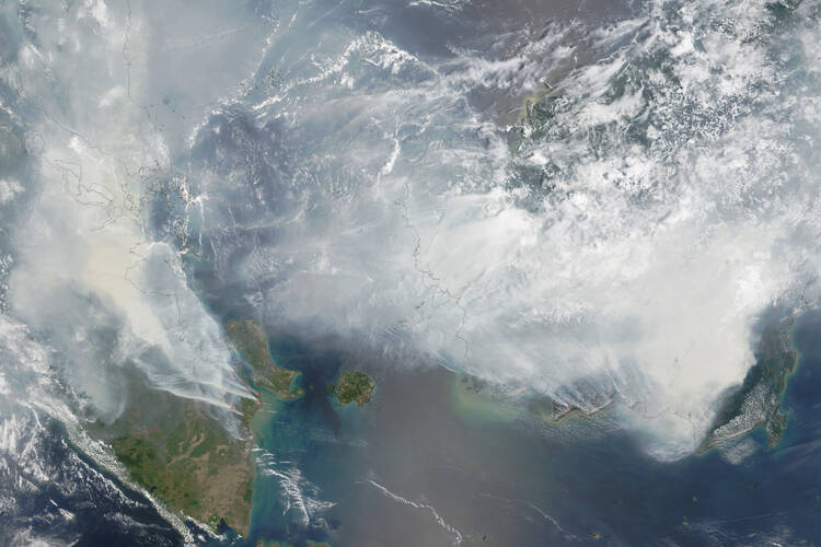In this NASA image smoke rises from hundreds of active fires across Borneo and Sumatra.
