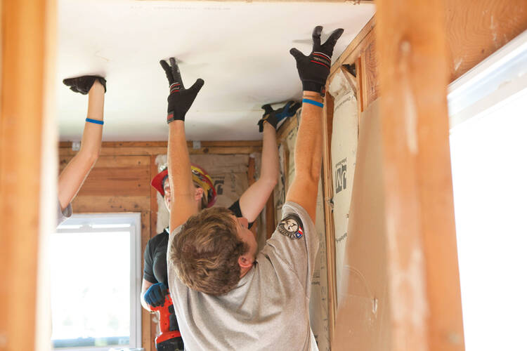 ￼HELPING HANDS. AmeriCorps members put up dry wall after the tornado in Joplin, Mo