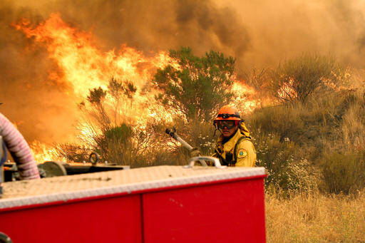 Los Angeles County firefighters pause to fight the flames due to erratic winds in Placenta Caynon Road in Santa Clarita, Calif., July 24 (AP Photo/Matt Hartman).