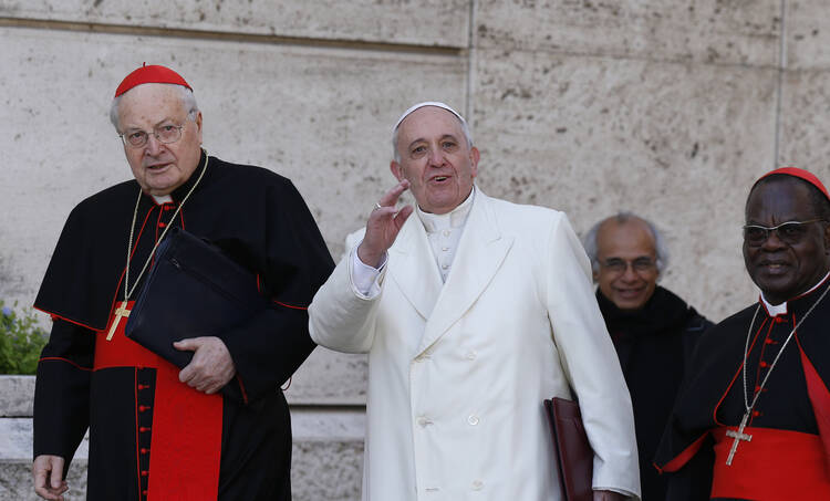 Pope Francis greets the press as he arrives with Cardinals Angelo Sodano and Laurent Monsengwo Pasinya to lead a meeting of cardinals.