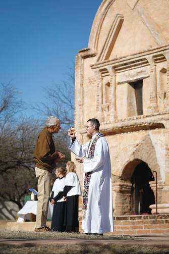 TAKE THIS. Sean Carroll, S.J., gives Communion during Mass at Tumacacori National Historical Park in Tumacacori, Ariz., Jan. 10.