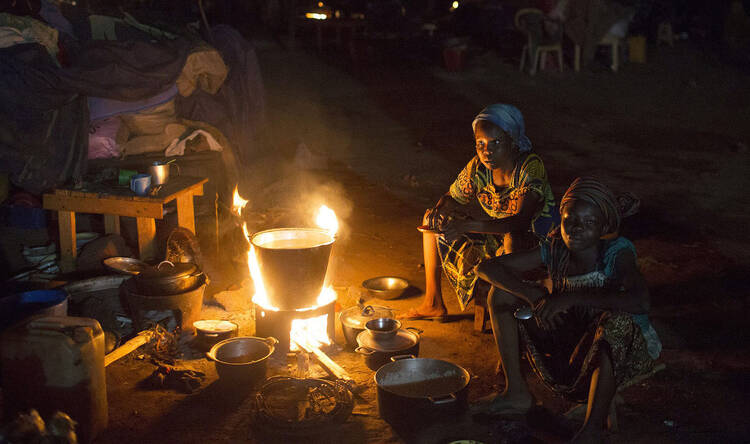 Displaced Muslim women prepare food next to their belongings in Bangui, Central African Republic.
