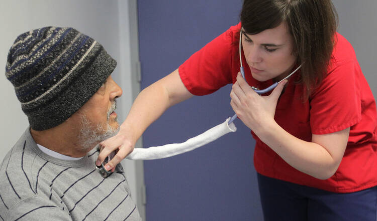 Mari Etzel, 25, a nurse who works as a volunteer at Christ House though the Catholic Volunteer Network, treats a patient in 2011 at the medical facility in Washington, February 17, 2012. (CNS photo/Bob Roller)