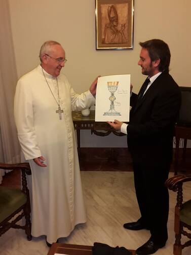 Adrian Pallarols shows Pope Francis the design for the chalice.