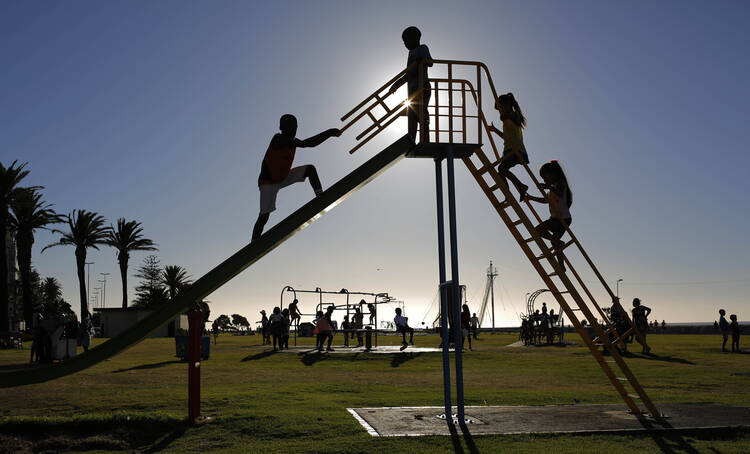Children climb a slide in the public play area in Three Anchor Bay in Cape Town, South Africa, Dec. 29, 2014. 