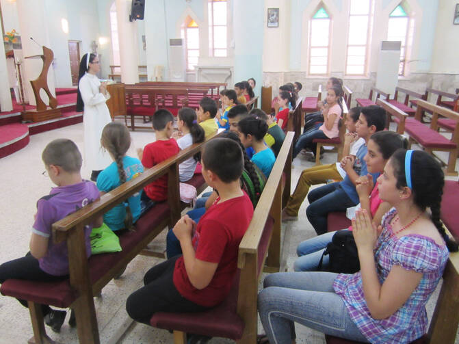 Children prepare for first Communion in Karamless, Iraq, Aug. 1. Because Islamist terrorists drove these Christian families from their homes, their Aug. 8 ceremony never happened. (CNS photo/Sahar Mansour)