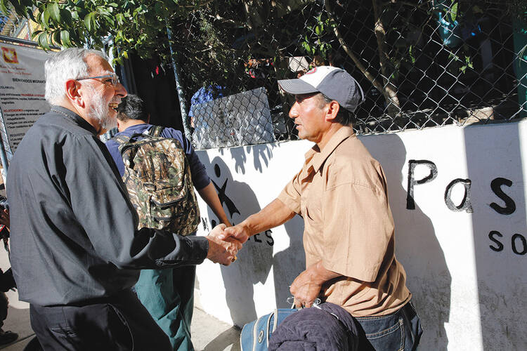 CARE OF SOULS. Bishop Gerald F. Kicanas of Tucson greets men entering a soup kitchen in Nogales, in northern Mexico, in 2014.