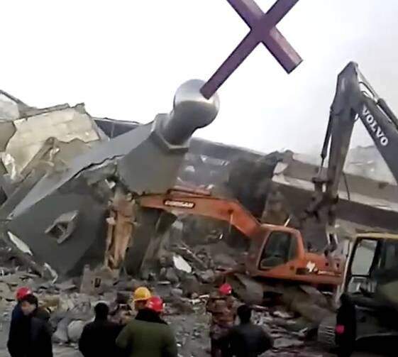 In this image taken from a video shot on Jan. 9, 2018, by China Aid and provided to the Associated Press, people in hard hats stand amid the remains of the Golden Lampstand Church in Linfen in northern China's Shanxi province. (China Aid via AP)