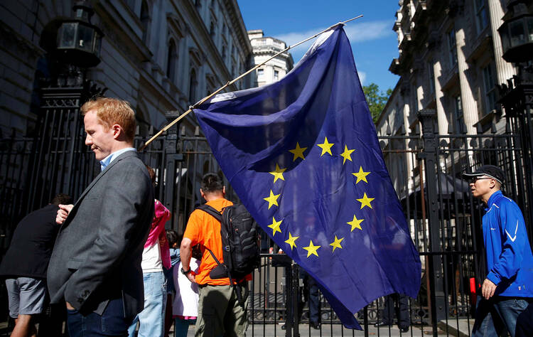 FAREWELL TO ALL THAT. A man carries a European Union flag in London on June 24, a day after voters in the United Kingdom decided to leave the EU (CNS photo/Neil Hall, Reuters). 