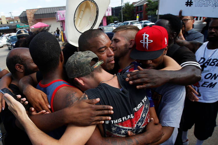 People hug after taking part in a prayer circle July 10 following a Black Lives Matter protest in the wake of multiple police shootings in Dallas (CNS photo/Carlo Allegri, Reuters).