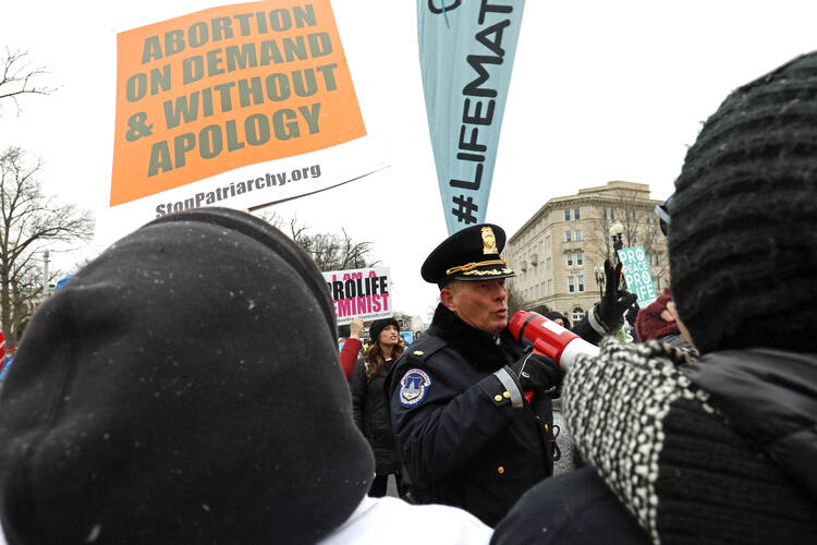 A police officer warns demonstrators who support legal abortion that they would be arrested if they continued to block the path of pro-life advocates during the March for Life in Washington, Jan. 22 (CNS photo/Gregory A. Shemitz). 