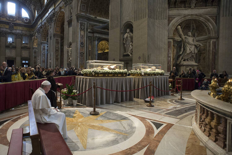 MISSIONARIES OF MERCY. Pope Francis prays in front of the coffins containing the exhumed bodies of Sts. Padre Pio and Leopold Mandic displayed in St. Peter's Basilica at the Vatican, Feb. 6 (CNS photo/L'Osservatore Romano via Reuters).