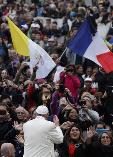 Pope Francis passes the flags of the Vatican and France as he arrives to lead his general audience in St. Peter's Square at the Vatican, Nov. 18 (CNS photo/Paul Haring).