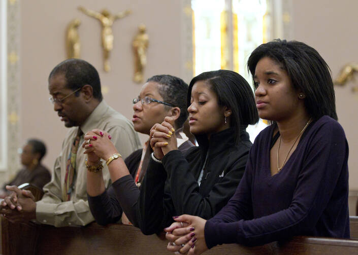 A family prays after arriving for Sunday Mass in 2011 at St. Joseph's Catholic Church in Alexandria, Va.