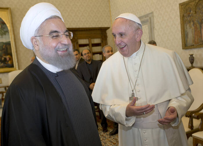 Pope Francis shares a light moment with Iranian President Hassan Rouhani during a private meeting at the Vatican Jan. 26 (CNS photo/Andrew Medichini, pool via Reuters).