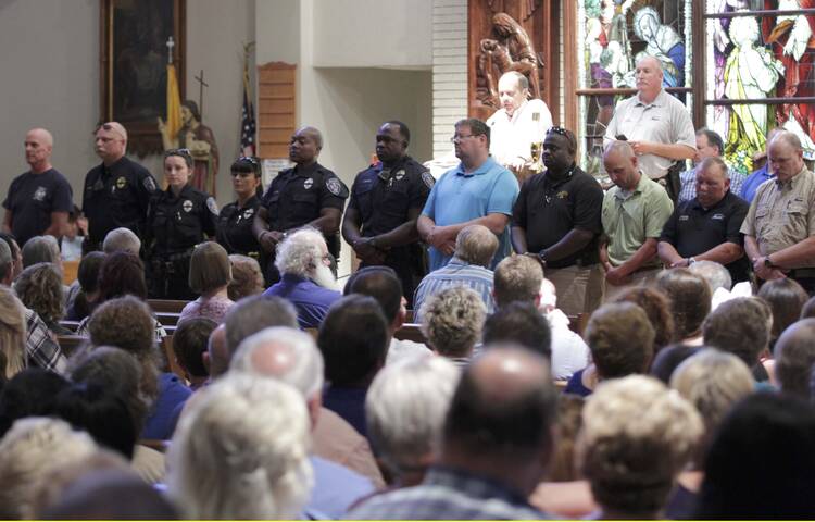 Police officers attend a July 17 vigil at St. John the Baptist Church in Zachary, La., for the fatal attack on policemen in Baton Rouge, La. (CNS photo/Jeffrey Dubinsky, Reuters)