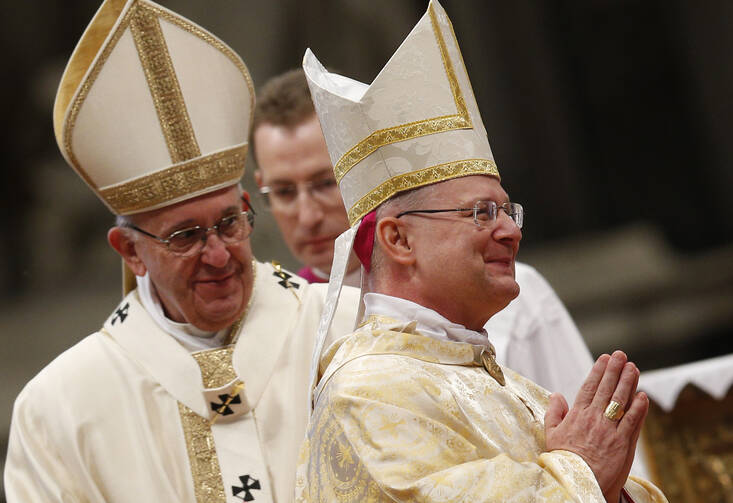 New Archbishop Peter B. Wells, a native of Tulsa, Oklahoma, right, smiles during his ordination to the episcopate by Pope Francis in St. Peter's Basilica at the Vatican, March 19. 