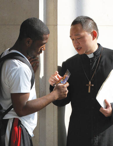 Michael Zhang, a seminarian, talks with a young man in New York.