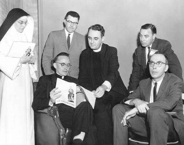 The Rev. Andrew M. Greeley, seated left, talks with fellow speakers following a symposium on "New Horizons in Catholic Thought" in 1962.