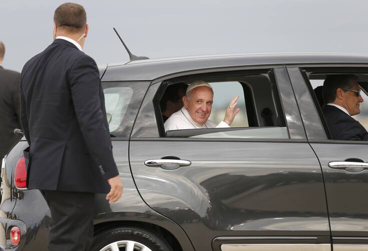 Pope Francis waves as he rides away in a Fiat after a short arrival ceremony on the airfield at Joint Base Andrews outside Washington Sept. 22, 2015. (CNS photo/Jonathan Ernst, Reuters)