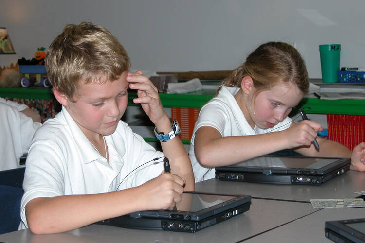 Third-graders familiarize themselves with their new tablet computers at Monte Cassino School in Tulsa, Okla. 