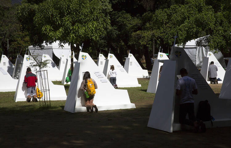 World Youth Day pilgrims take advantage of temporary confessionals set up at Rio park (CNS Photo/Tyler Orsburn).