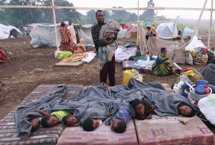 Congolese children displaced by fighting rest in open at camp in Uganda, July 13.