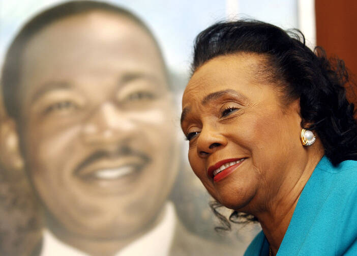 Coretta Scott King, beside a portrait of her husband, Martin Luther King, Jr.
