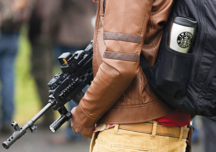 STAND YOUR GROUND? Chris Williams holds a firearm as he attends a rally against Initiative 594 at the state capitol in Olympia, Wash., Dec. 13, 2014. 