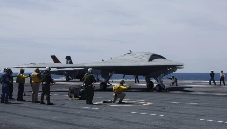 Crew prepares to launch pilot-less drone combat aircraft from aircraft carrier in Atlantic Ocean off coast of Virginia, May 21, 2013.