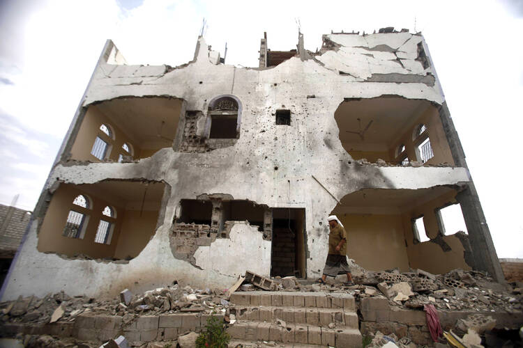 Tribesman walks near a building damaged last year by U.S. drone airstrike in Yemen.