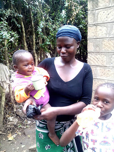 Faith Teta with her children outside her home in Dolo Town, which has been hard hit by the Ebola outbreak. Photo by Sheilia Passewe for USA Today