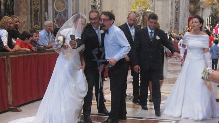 Members of the wedding party pose for selfies before Mass begins. 