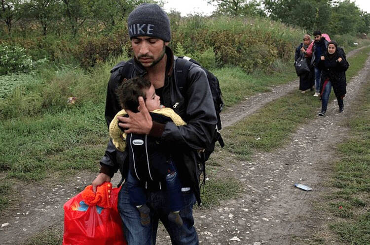 A Syrian family walks in the direction of the Tovarnik train station in Croatia. JRS South East Europe is providing support to forced migrants in Macedonia, Kosovo and Croatia on a daily basis. (Sergi Cámara — Jesuit Refugee Service)
