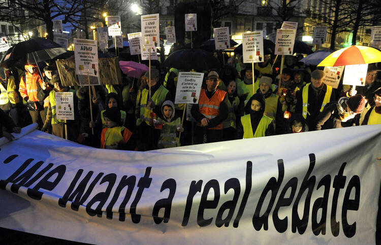 Protesters in Brussels hold banners on Feb. 11 against legislation authorizing euthanasia for children.