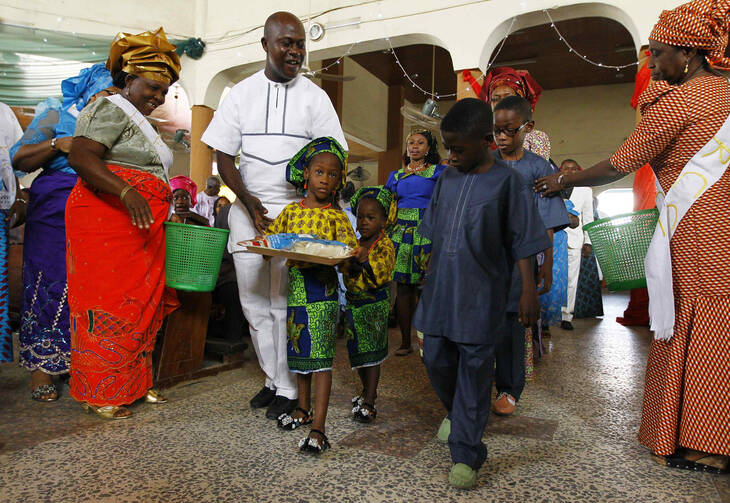 A family walks with gifts toward the altar during a New Year's Mass of thanksgiving at Holy Rosary Church in Abuja, Nigeria.