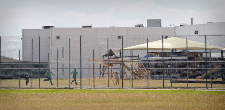 Children play in a double-fenced playground area outside the T. Don Hutto Family Residential Facility in Taylor, Texas. (CNS photo/Bahram Mark Sobhani)