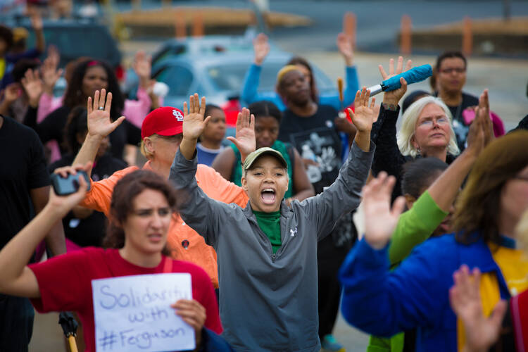 Protesters hold their hands in the air during an Aug. 16 demonstration against the shooting death of Michael Brown in Ferguson, Mo. The unarmed teen was shot and killed Aug. 9 by a police officer. (CNS photo/Lisa Johnston, St. Louis Review)