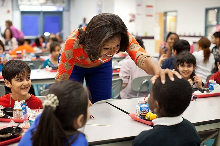 Michelle Obama has lunch with students. (public domain image)