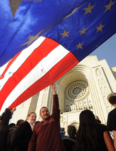 A man holds a large U.S. flag before an Oct. 14 Mass and Pilgrimage for Life and Liberty at the Basilica of the National Shrine of the Immaculate Conception in Washington. (CNS photo/Leslie E. Kossoff) (Oct. 15, 2012)