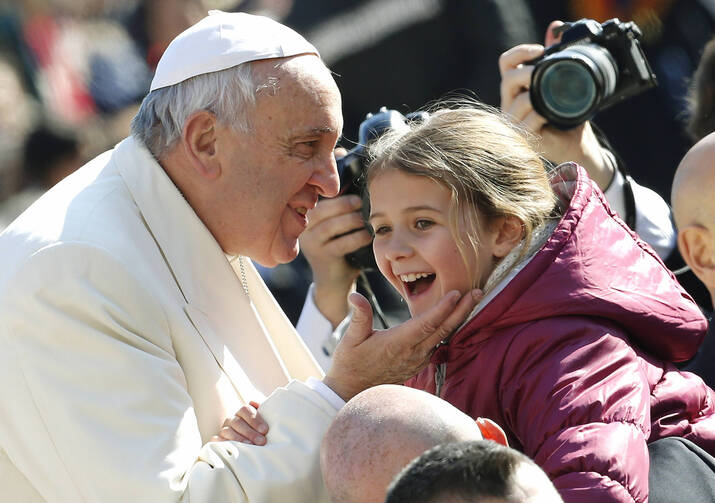 A child reacts after being kissed by Pope Francis as he arrives to lead the weekly audience in St. Peter's Square at the Vatican Feb. 18. (CNS photo/Giampiero Sposito, Reuters) 